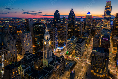 Aerial Drone View of Philadelphia Skyline at Sunset with Glowing City Lights with Town Hall in Foreground 