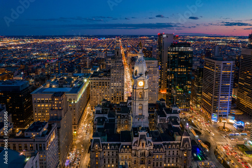 Aerial Drone View of Philadelphia Skyline at Sunset with Glowing City Lights with Town Hall in Foreground 