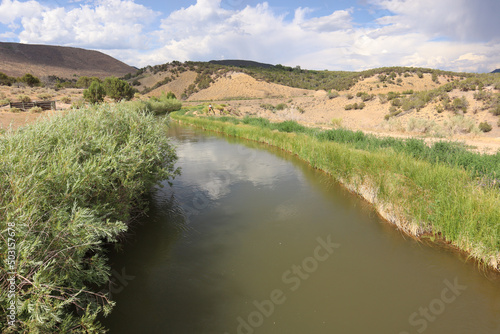 Landscape view of aqueduct channel water in Paonia, Colorado, USA against a cloudy sky photo