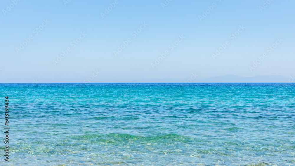 Turquoise sea and blue sky. Landscape with sea waves at a summer resort. Summer holiday concept