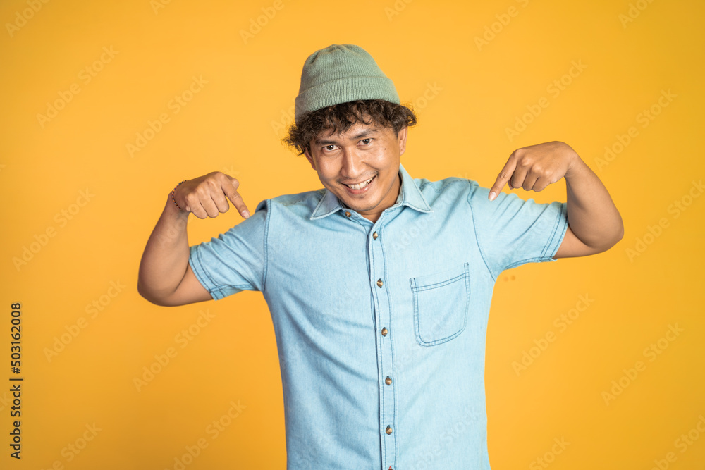 excited young man with two fingers pointing down on isolated background