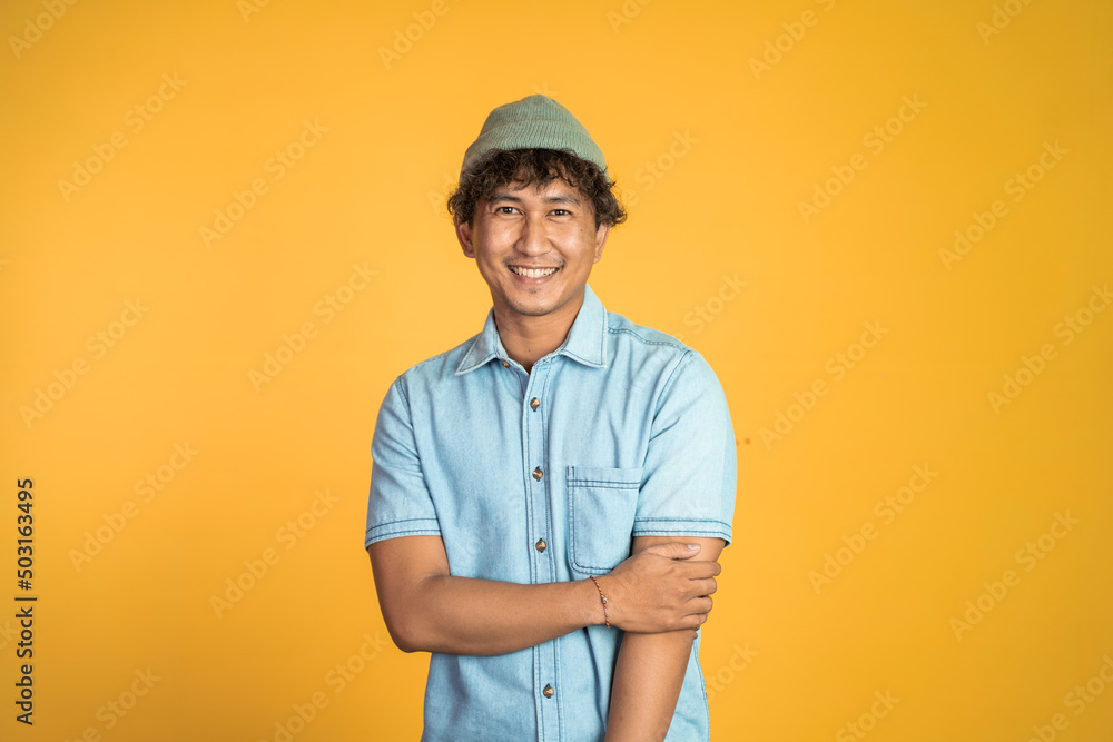 portrait of young asian man stand with crossed hands on isolated background