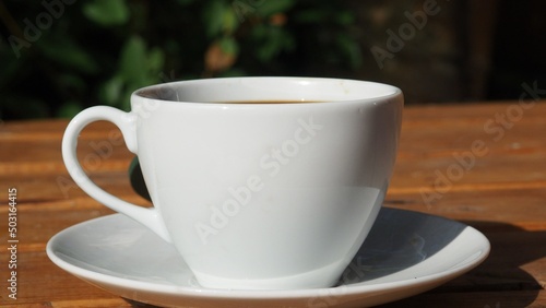 Coffee cup and fresh baked croissants  in a restaurant or cafe  smart phone on white background. Top View. girl preparing breakfast in the in the courtyard. a cup of coffee  watching the news