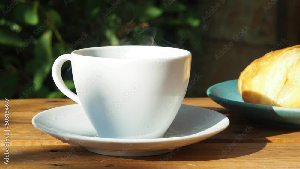 Coffee cup and fresh baked croissants, in a restaurant or cafe, smart phone on white background. Top View. girl preparing breakfast in the in the courtyard. a cup of coffee, watching the news Coffee cup and fresh baked croissants, in a restaurant or cafe, smart phone on white background. Top View. girl preparing breakfast in the in the courtyard. a cup of coffee, watching the news