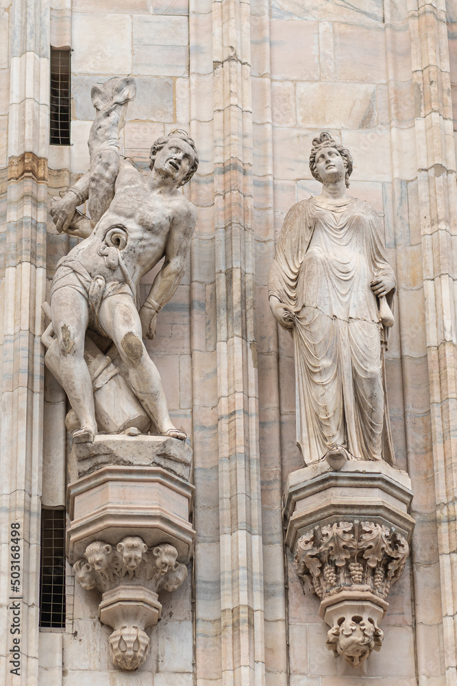 Obraz premium The Saint Erasmus of Formia statue on Milano Cathedral or Duomo, is the cathedral church of Milan, Lombardy, Italy. Dedicated to the Nativity of St Mary (Santa Maria Nascente)