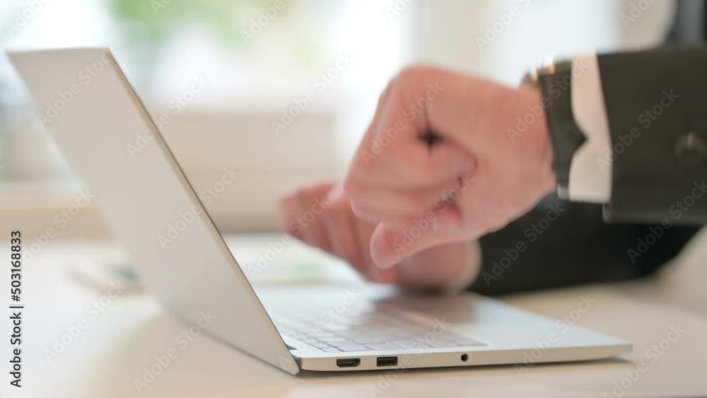 Close up of Hands of Middle Aged Businessman Checking Watch, with Laptop Close up of Hands of Middle Aged Businessman Checking Watch, with Laptop