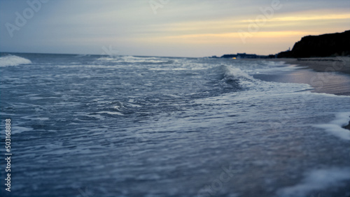 Sunset sea beach waves crashing romantic island coast. Ocean blue water splash.