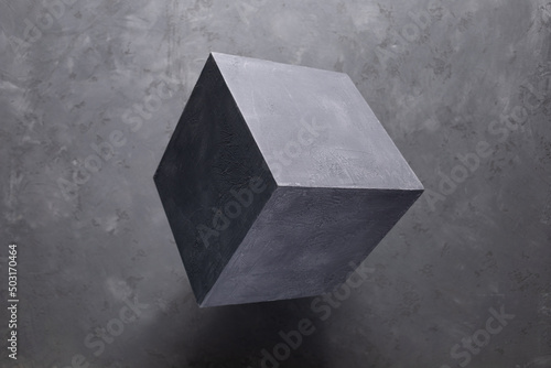 Cement cube on abstract grey floor background texture. Geometric model concept
