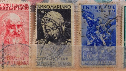 Wallpaper Mural Vintage postage stamps showing portraits of various artists and Leonardo Da Vinci head. Browsing a stockbook containing a collection of canceled Italian stamps. Close-Up  Torontodigital.ca