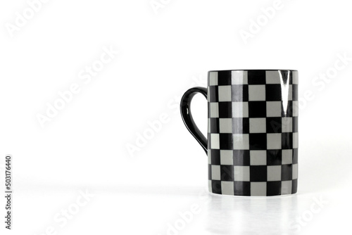 Mug with black and gray checkered pattern isolated on a white background with copy space