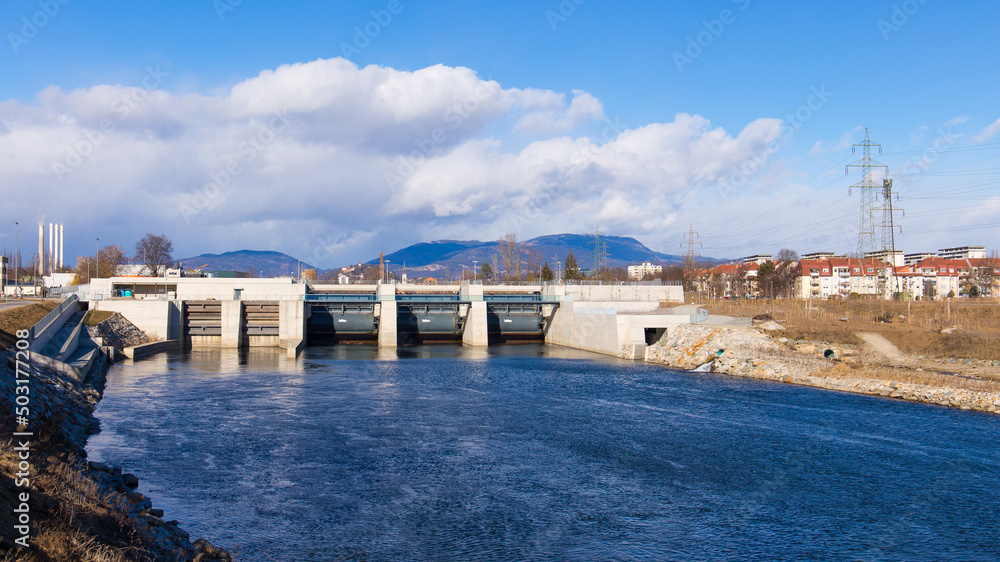 View of the hydro-electric power plant Puntigam in Graz, Austria at the river Mur on a stormy winter day