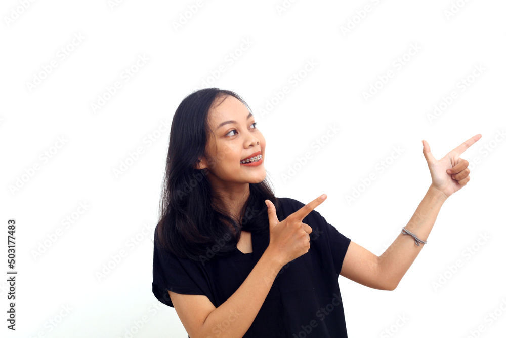 Portrait of beautiful woman wearing black shirt pointing left side and smile, cheerful expression Portrait of beautiful woman wearing black shirt pointing left side and smile, cheerful expression