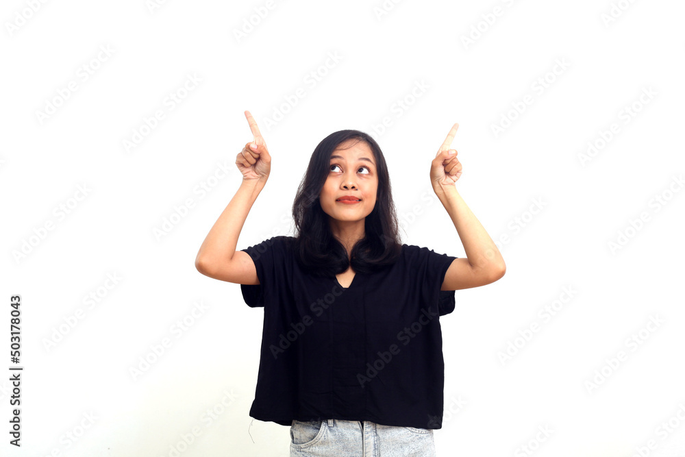 Beautiful asian woman in black t-shirt pointing fingers up, standing over white background Beautiful asian woman in black t-shirt pointing fingers up, standing over white background