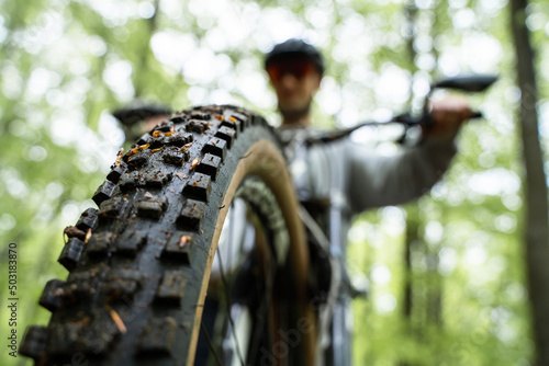 Front tire closeup - Young caucasic man riding a bike, enduro downhill mtb photo