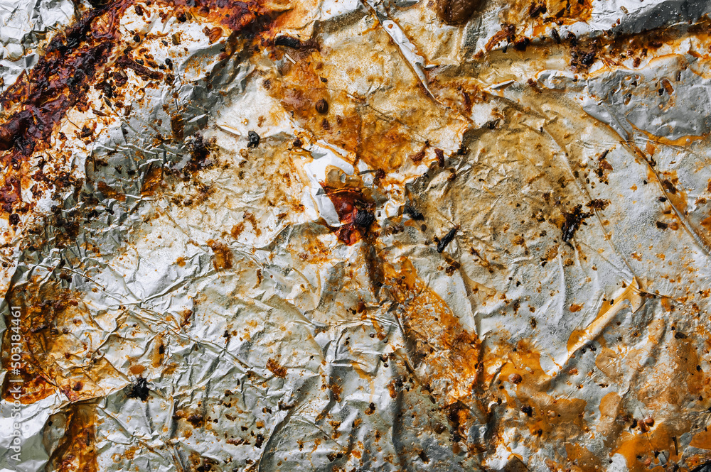 Background, texture, top view of dirty, greased, sunflower oil, after cooking a meat dish, colored foil. Food photography.