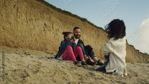 Calm family spend time together on sea beach. Happy people taking photos outside