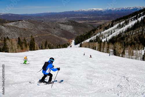 Enjoying skiing downhill at Park City Canyons Ski Area in Utah. Late spring weather conditions. Amazing sunny day and beautiful nature around.