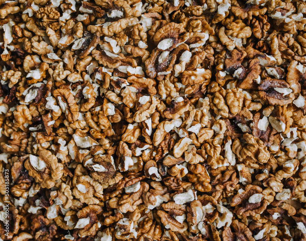 Background, texture of many brown walnuts, shelled nuts lying on the table. Food photography, top view, concept. Background, texture of many brown walnuts, shelled nuts lying on the table. Food photography, top view, concept.