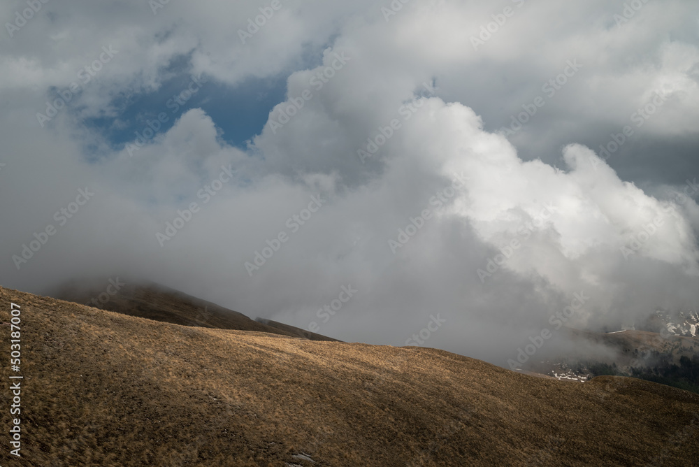 a beautiful cloud creeps along the mountain slope