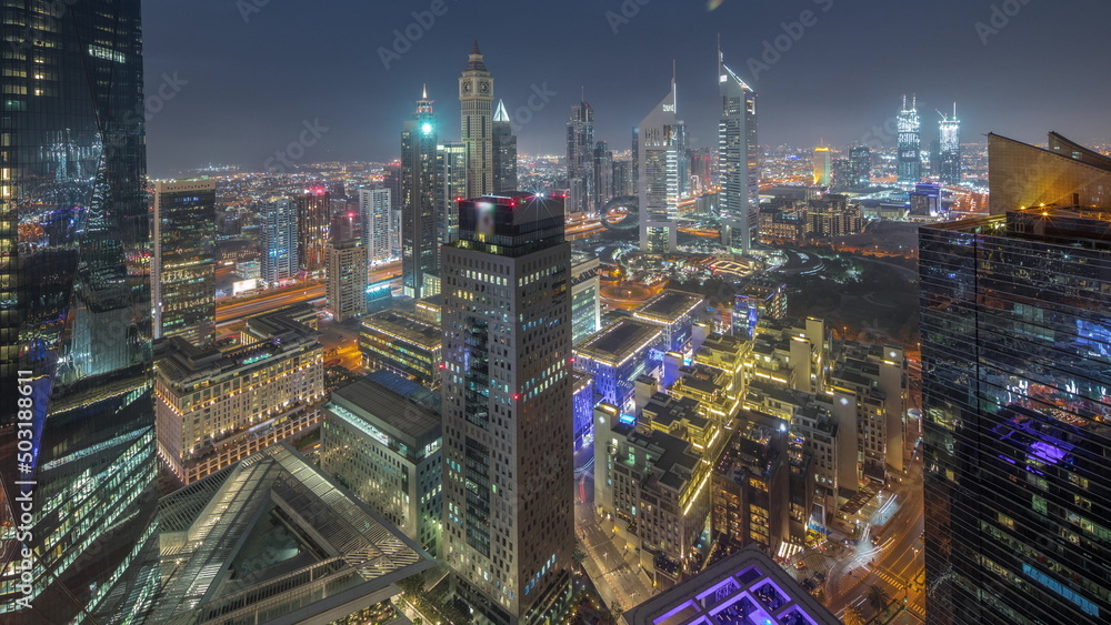 Fototapeta premium Panorama of futuristic skyscrapers after sunset in financial district business center in Dubai day to night timelapse
