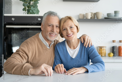 Happy elderly married couple looking at camera