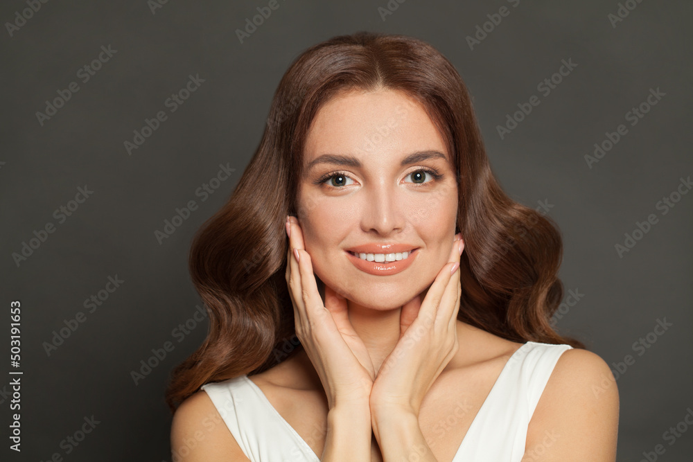 Beautiful woman with perfect clean skin holding her hands near her face on gray background. Facial treatment and skin care concept Beautiful woman with perfect clean skin holding her hands near her face on gray background. Facial treatment and skin care concept