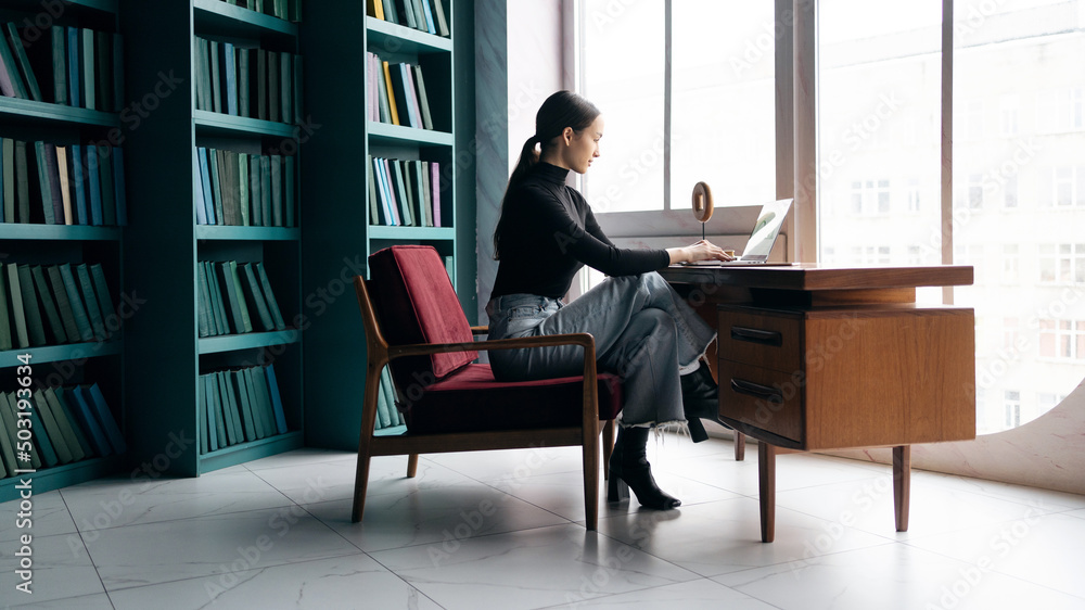 Business woman working in a stylish office, uses a laptop, report to a freelancer company Business woman working in a stylish office, uses a laptop, report to a freelancer company