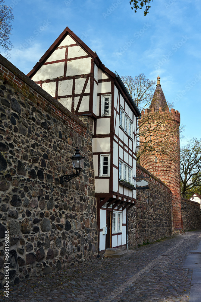 Stone, medieval walls with a historic tower of a two-story house in the city of Neubrandenburg