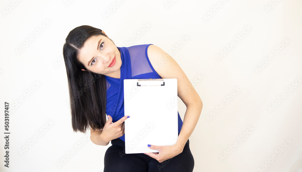 Cute and successful CEO assistant wearing blue blouse happily showing the benefits of her company, holding a clipboard with her hand, white background Cute and successful CEO assistant wearing blue blouse happily showing the benefits of her company, holding a clipboard with her hand, white background