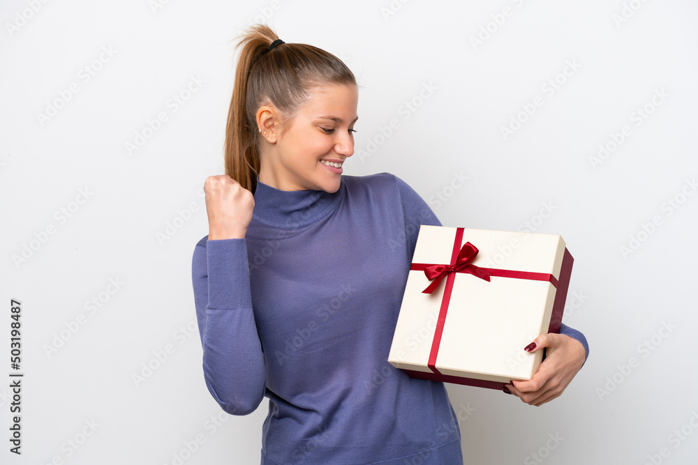 Young caucasian woman holding a gift isolated on white background celebrating a victory Young caucasian woman holding a gift isolated on white background celebrating a victory