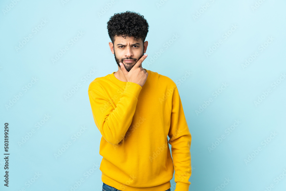 Young Moroccan man isolated on blue background thinking Young Moroccan man isolated on blue background thinking