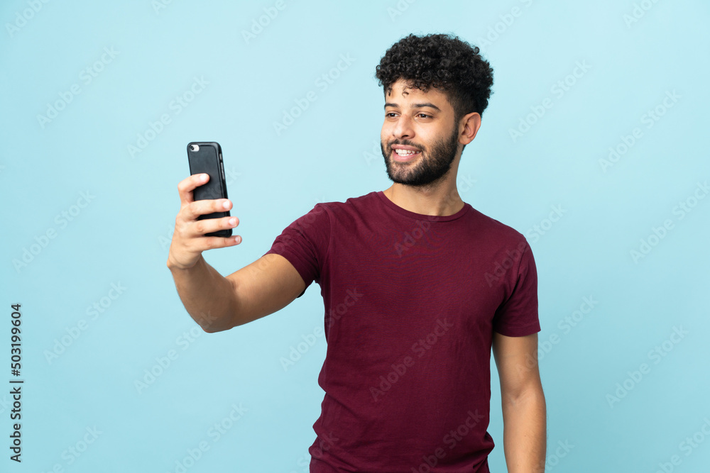 Young Moroccan man isolated on blue background making a selfie Young Moroccan man isolated on blue background making a selfie
