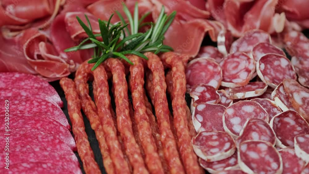 Meat plate with assortment of various tasty Spanish, french or Italian appetizers - sliced prosciutto, sausage, ham, boiled pork, balyk, jamon, sandwich, cheese, salami. Meat platter rotating Meat plate with assortment of various tasty Spanish, french or Italian appetizers - sliced prosciutto, sausage, ham, boiled pork, balyk, jamon, sandwich, cheese, salami. Meat platter rotating