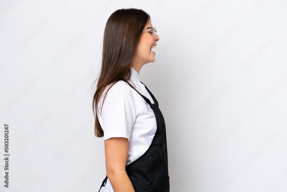 Restaurant Brazilian waiter woman isolated on white background laughing in lateral position Restaurant Brazilian waiter woman isolated on white background laughing in lateral position