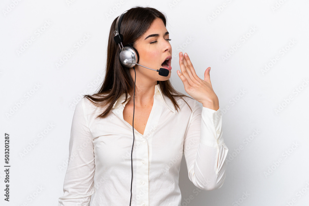 Telemarketer caucasian woman working with a headset isolated on white background yawning and covering wide open mouth with hand Telemarketer caucasian woman working with a headset isolated on white background yawning and covering wide open mouth with hand