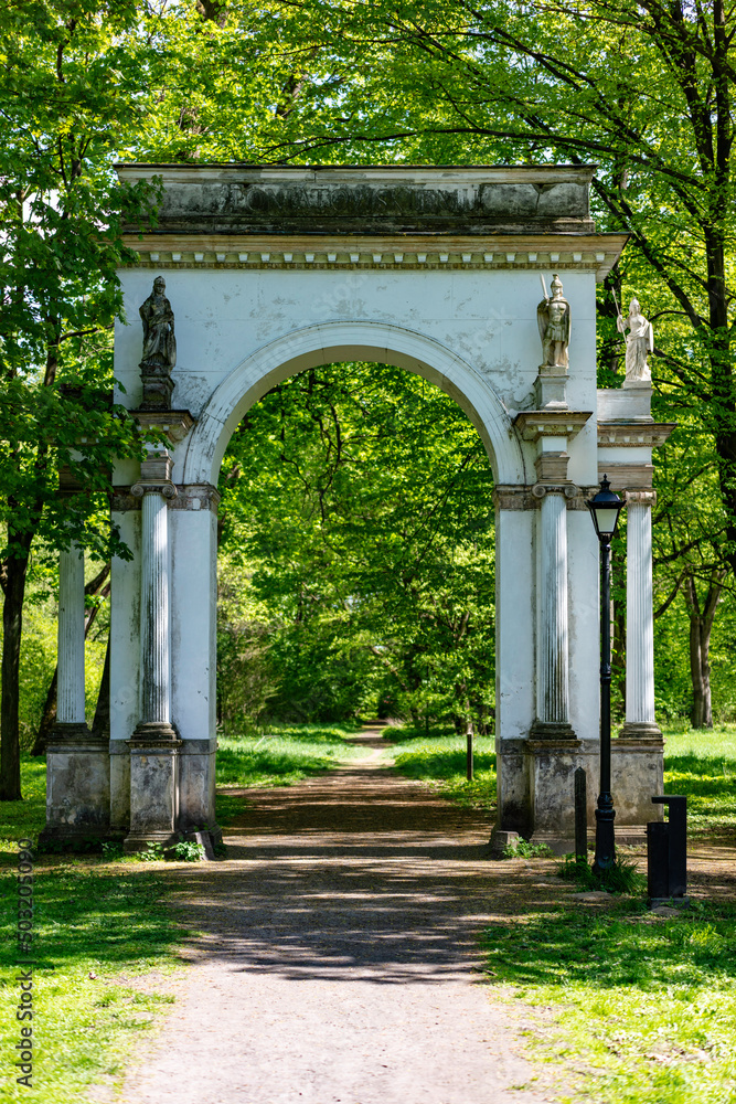 Fototapeta premium Zespół pałacowo-parkowy w Jabłonnie .Romantyczny park koło Warszawy, ścieżki rośliny, krzewy, drzewa, rzeźby. Wiosna.