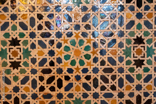 Ornamental medieval ceramic tiles of walls in Nasrid Palaces in the Alhambra palace Granada, Andalusia, Spain