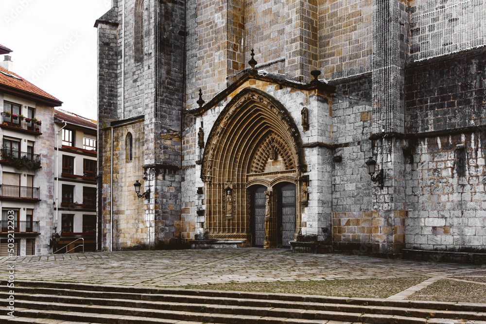 Fototapeta premium Entrance door and main facade of old stone church in Guernica, Basque Country, Spain. Romanesque architecture concept.