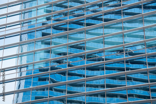 Blue sky reflection in glass facade of building
