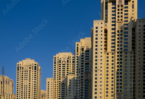 Sand coloured towers of Jumeirah Beach Residence, blue sky background © Blazenka