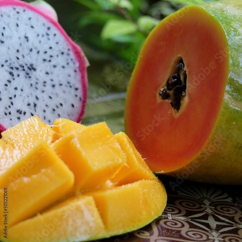 Cut papaya  dragonfruit and mango in the table close up.