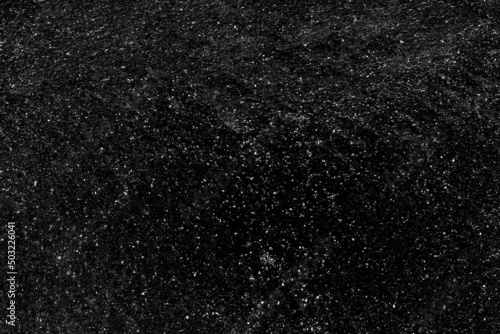 Rugged black metal sheet with scattered white grunge texture