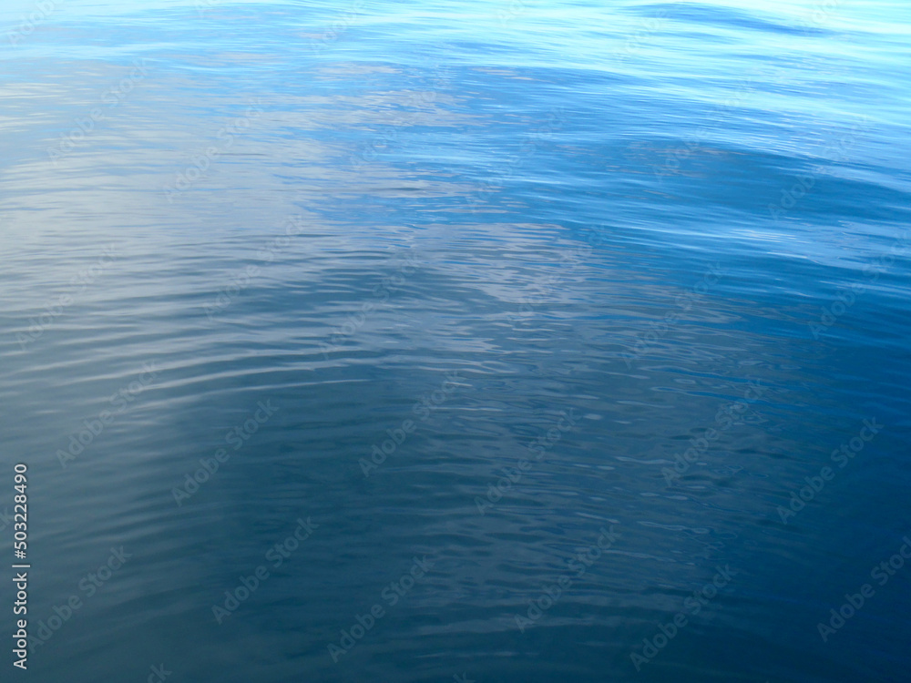 Calm sea surface texture that changes from deep indigo to gray waving texture photograph.