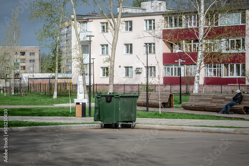 City street, benches, trash can and houses. © Ilya