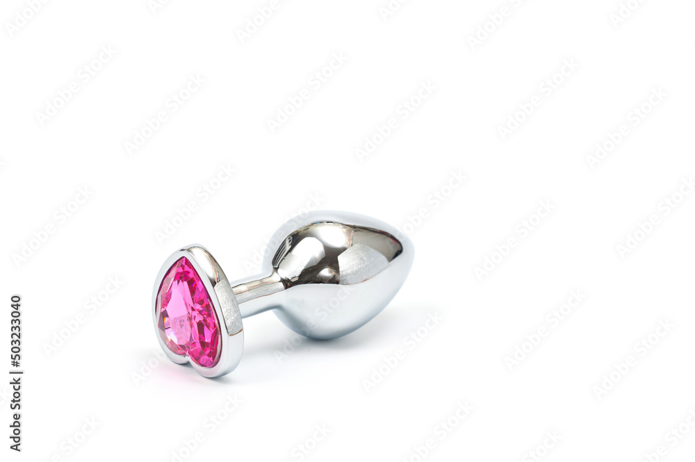 Metal butt plug with a decorative pink heart-shaped stone at the end. Metal butt plug with a decorative pink heart-shaped stone at the end.
