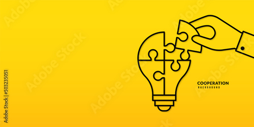 Hand holding  jigsaw puzzle on yellow background, Business solutions, cooperation and teamwork concept. Co-worker planning and strategy