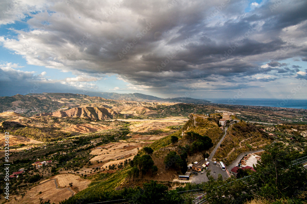 Terra di Calabria con nuvole cupe che sovrastano il paesaggio