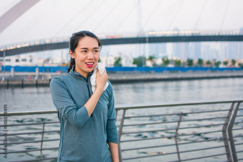 Fototapeta premium Woman taking rest from an outdoors workout and running outdoors