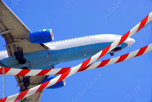 Aircraft flight ban. Ribbon with red stripes crossing out the plane. Prohibition sign.