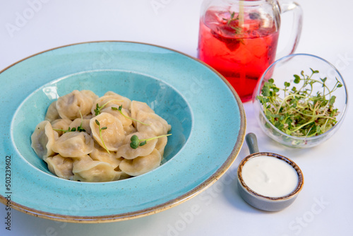 Dumplings with meat, sour cream, micro greens